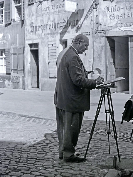 Artist. Male artist painting in a street in Germany Date: circa 1968