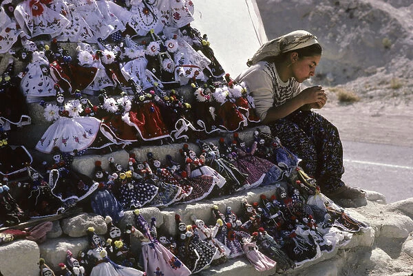 A young girl and her doll and trinket souvenir stall, Goreme