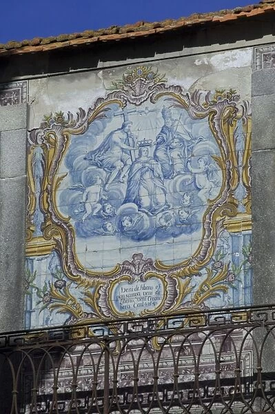 A beautiful blue and white tiled azuleju tableau with elaborate gold tiled frame preserved in an old wall in the City of Oporto, Portugal, Europe