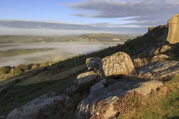Mist clears from valley, fields and woods, from Curbar Edge at sunrise, autumn dawn