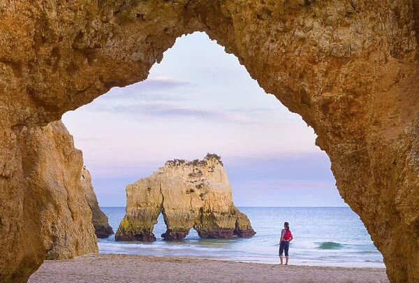 Portugal, Algarve, Alvor, Prainha, woman standing on beach (MR)