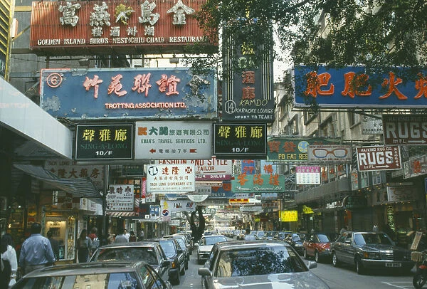 10021642. HONG KONG Markets Busy downtown street with traffic and overhanging shop signs
