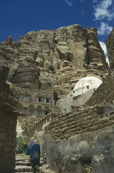 10050996. YEMEN Thula Houses in hills one white domed. Two women walking up steps