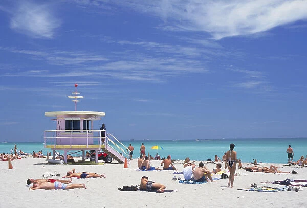 10065350. USA Florida Miami Sunbathers on the beach by a colourful lifeguard hut