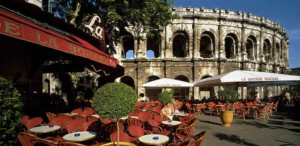 20027578. FRANCE Gard Nimes. Cafe with outside tables in front of the Arenes