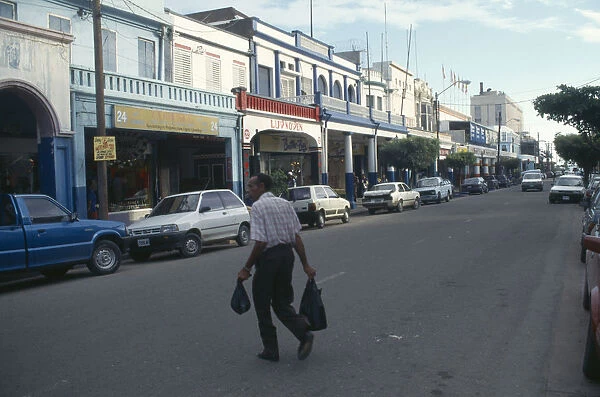 20030788. CARIBBEAN Jamaica Kingston Man crossing King Street towards parked cars