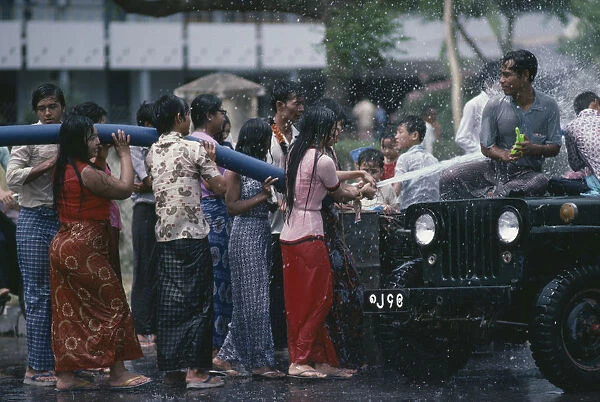 20039211. myanmar, mandalay, buddhist water festival. crowds spraying water from hose