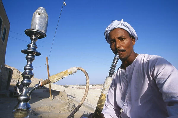 20043970. EGYPT Dra Abul Naga Man smoking sheesha water pipe