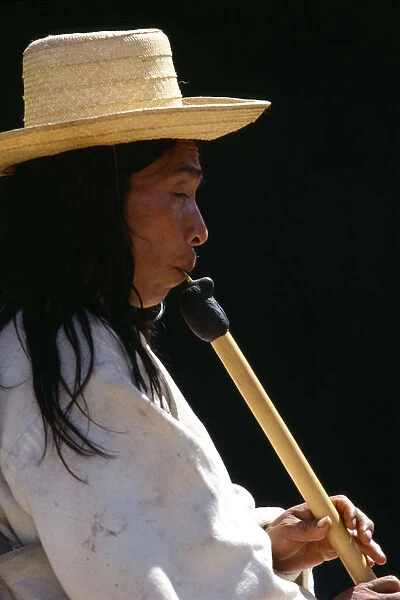 20053875. COLOMBIA General Kogi man playing flute. Kogi flute resembles a huge matchstick