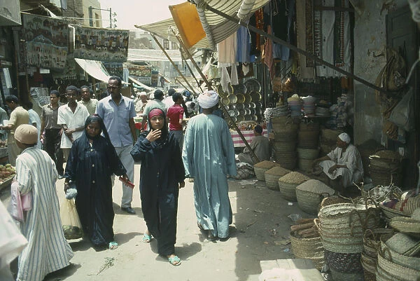 20068006. EGYPT Aswan Busy souk market scene with pulse vendor and crowds walking by