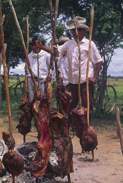20068951. COLOMBIA Casanare Carne a la llanera A group of men with cooked meat on sticks