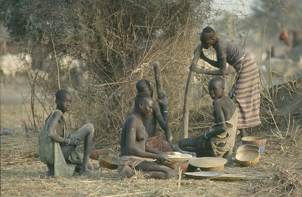 20073146. SUDAN Agriculture Dinka women pounding millet