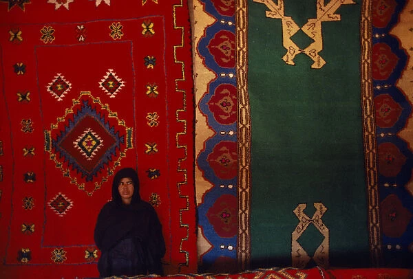 20076191. WESTERN SAHARA SADR Sahrawi woman standing in front of traditional carpets