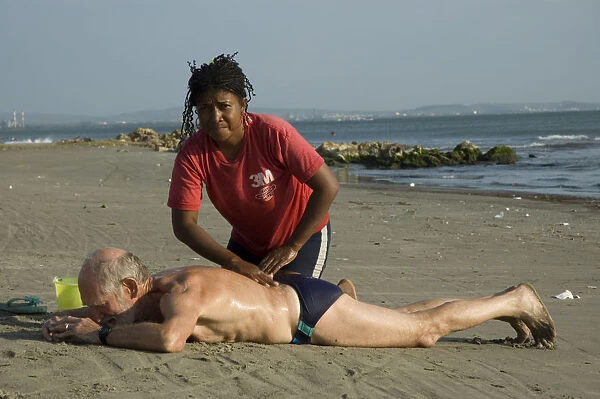 20077427. COLOMBIA Cartagena Tourist receiving a massage on Boca Grande beach