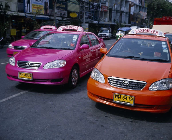 20081250. THAILAND Bangkok Pink and orange taxi cabs on busy road