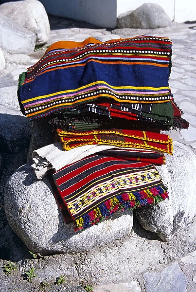 20084099. BULGARIA Bansko Colourful blankets on display on rocks outside gift