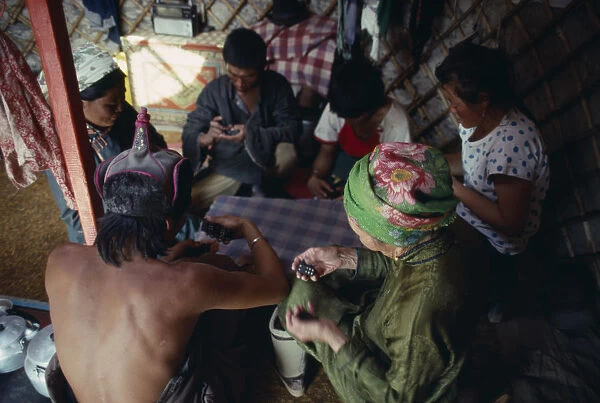 20085610. MONGOLIA People Playing game of dominoes inside yurt