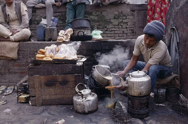 20085642. NEPAL Markets Food and Drink Tea-wallah preparing tea boiled with milk