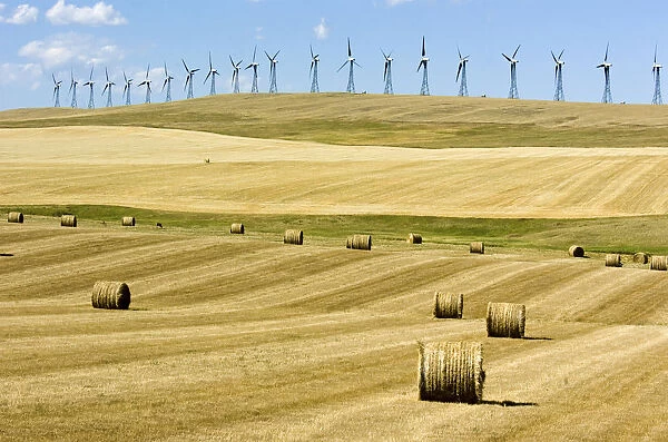 Canada, Alberta, Cowley Wind turbines and hay bales just after the harvest near Cowley