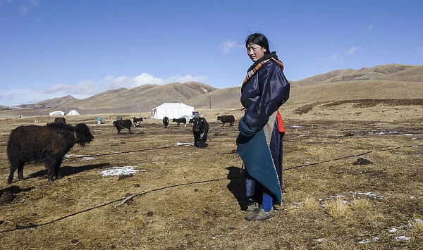 China, Tibet, Young woman from a Tibetan nomad family on a highland pasture near family
