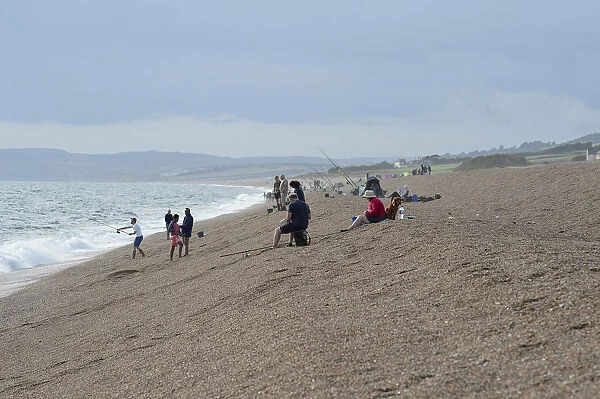 England, Dorset, Portland, Chesil Beach, Anglers fishing from the pebble beach