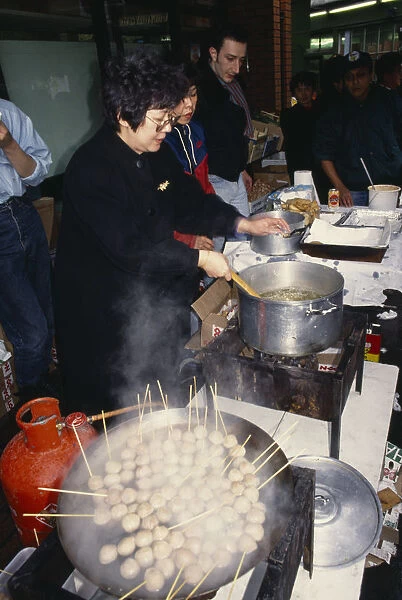 ENGLAND, London, Chinese New Year Women cooking on street stall during New Year