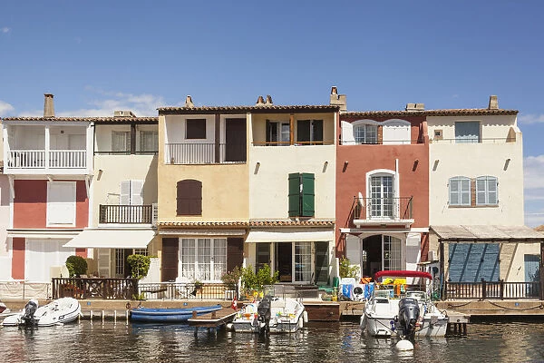 France, Port Grimaud, Boats moored in front of waterfront homes
