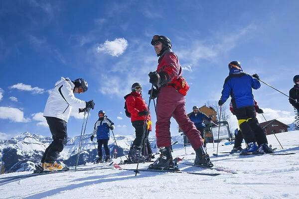 Group of skiers about to descend the mountain