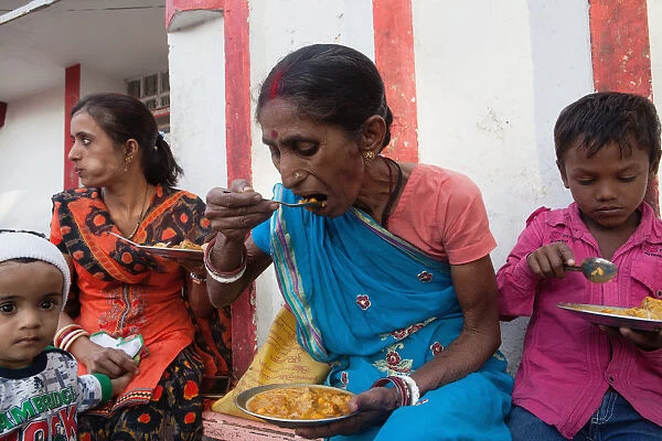 India, Bihar, Bodhgaya, A family eating vegetarian street food in Bodh