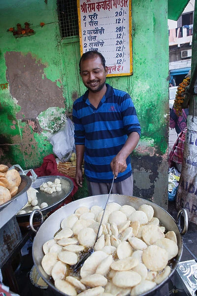 India, New Delhi, A cook frying kachori at a street stall in the old city of Delhi