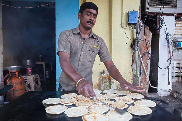 India, Pondicherry, Man frying parathas at a food hotel