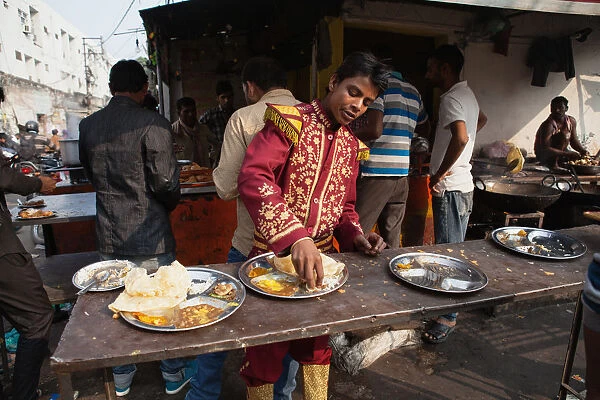 India, Uttar Pradesh, Lucknow, A man wearing his Band uniform eats a thali at a food hotel
