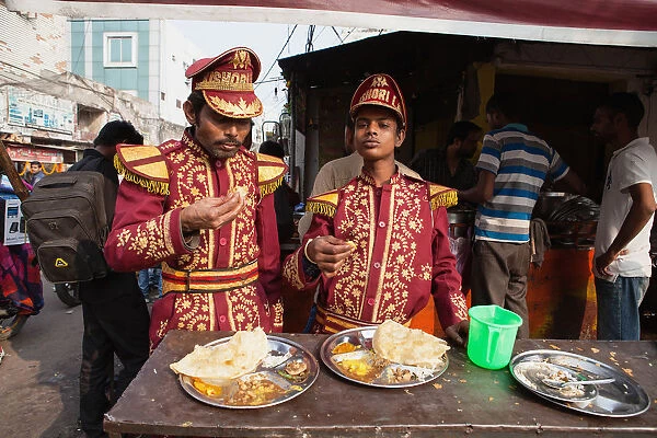 India, Uttar Pradesh, Lucknow, Musicians from a Band eat thali at a food hotel