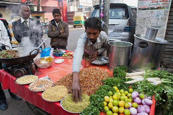India, Uttar Pradesh, Lucknow, A vendor prepares a vegetarian snack including mung bean srouts at his road-side stall