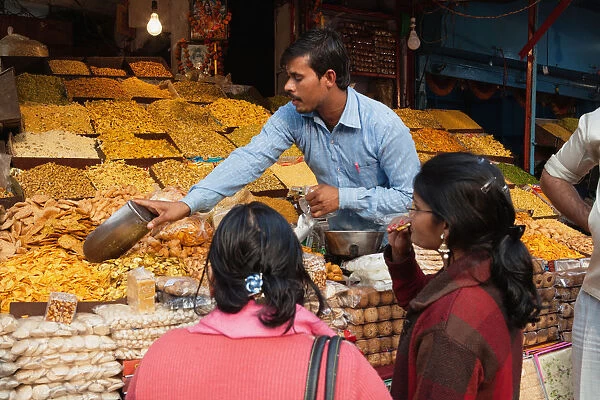 India, Uttar Pradesh, Lucknow, A vendor serves customers at his namkeen & savoury snacks stall