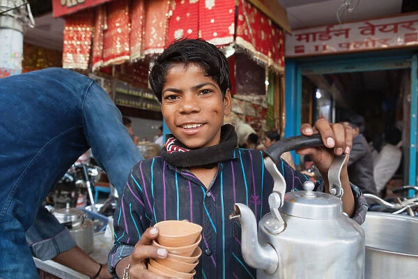 India, Uttar Pradesh, Varanasi, A chai boy serving tea