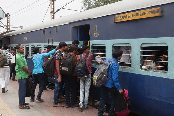India, West Bengal, Asansol, Passengers attempt to board an overcrowded second-class carriage of a train at Railway Station