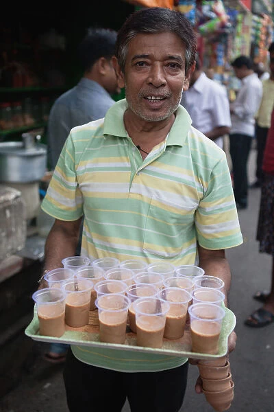 India, West Bengal, Kolkata, Chai vendor with a tray of tea in plastic cups in Sudder Street