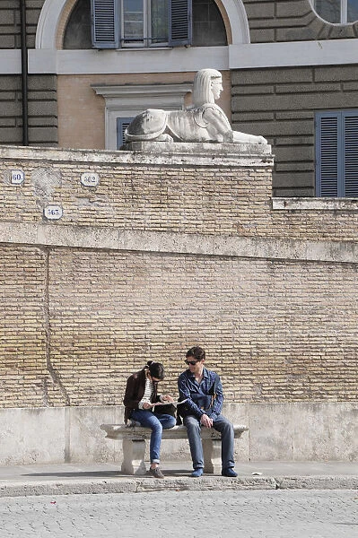 Italy, Lazio, Rome, Northern Rome, Piazza del Popolo, Sphinx statue & people reading in the square