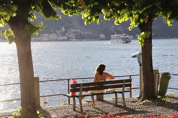 Italy, Lombardy, Lake Como, Bellagio, person on bench at sunset