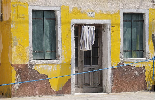 Italy, Veneto, Venice, Burano, faded yellow house