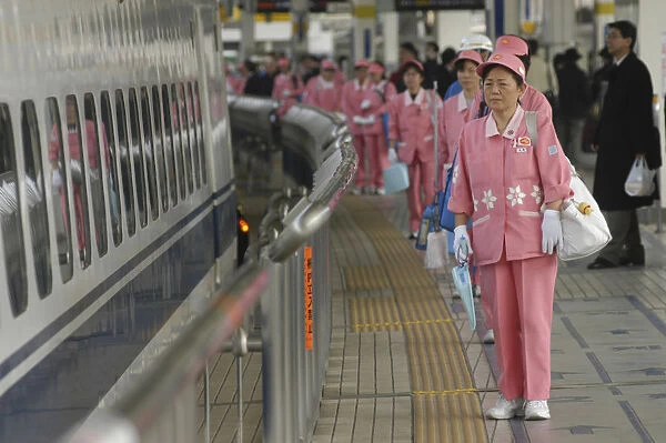 Japan Tokyo Ccleaning crew of middle aged women in uniform wait to board a shinkansen