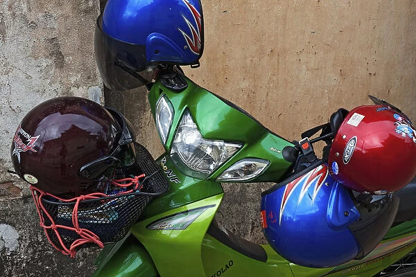 Laos, , Vientiane. Laos, Vientiane, One motorbike parked with four helmets