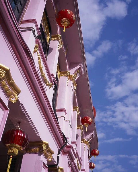 MALAYSIA, Penang, Georgetown Pink and gold painted shopfront hung with red