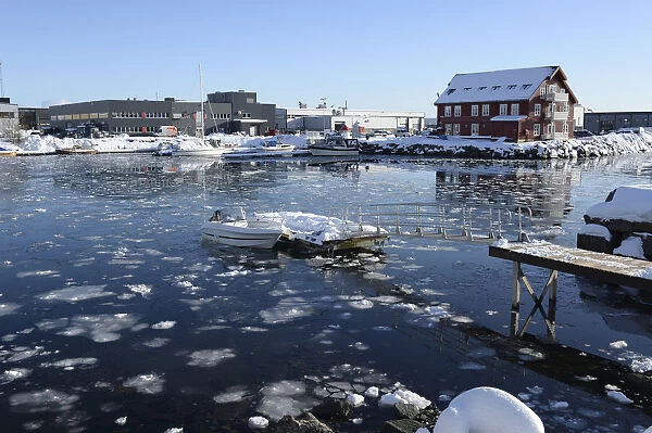 Norway, Lofoten, Svolvaer, Partially frozen inner harbour with floating ice and leisure boats