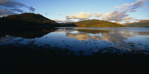 Scotland, Highlands, Loch Shira, View across Loch Shira in evening light with mountains reflected in the water towards Argyll Forest Park