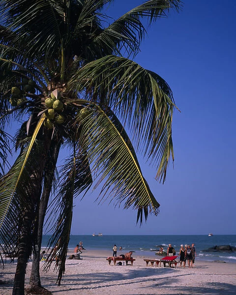 THAILAND, Hua Hin Western tourists on Hua Hin beach with distant boats on the water