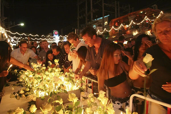 Tsunami. Thais and foreigners pay respect and have a vigil for the dead with candels and flowers in the heart of Patong on new years eve at midnight on the 31st Dec