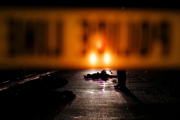 Bodies of two men are lit by a police car in Manila