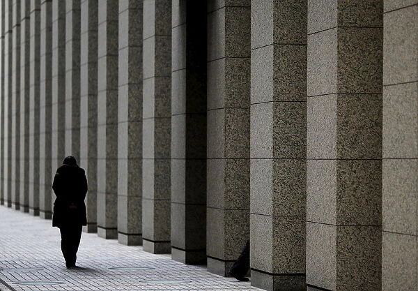 A person walks outside a building at Tokyos business district in Japan